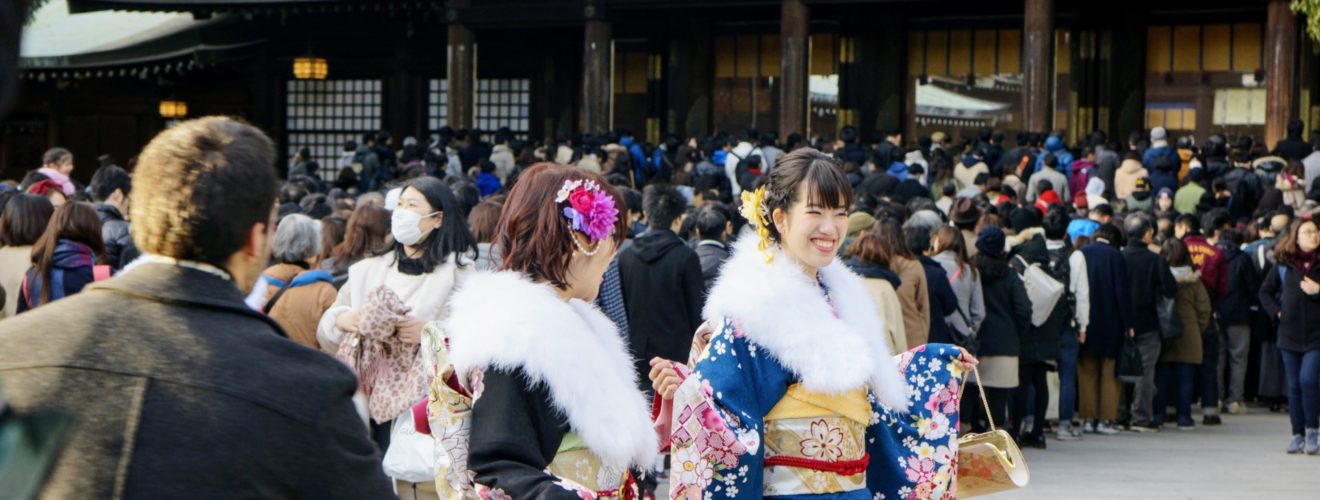 Unga damer i kimono som firar vid templet