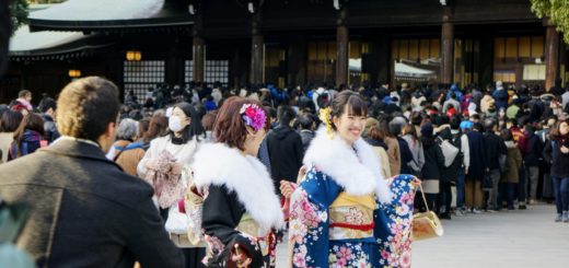 Unga damer i kimono som firar vid templet